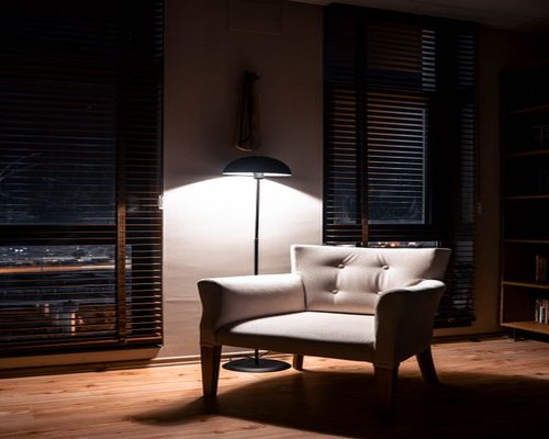 A well-lit cozy reading corner with a comfortable armchair and soft evening lighting