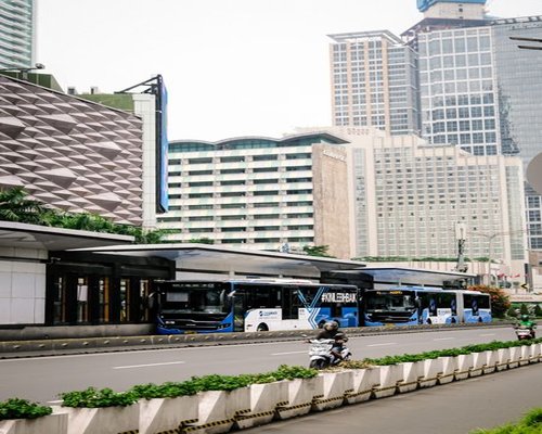 A commuter looking out the window of a TransJakarta bus instead of their phone